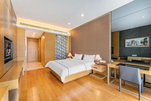 a bedroom with a bed and a desk and a television at eStay Residence·Poly World Trade Center Guangzhou in Guangzhou