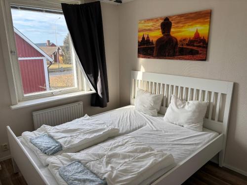 a white bed in a bedroom with a window at Emil Hemma in Järnforsen