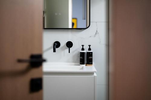 a bathroom with two bottles of wine and a mirror at Acharavi Beach Hotel in Acharavi