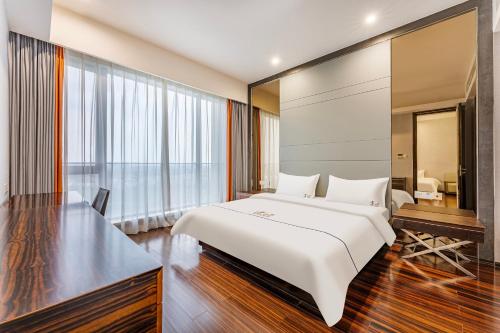 a bedroom with a large white bed and a desk at eStay Residence·Poly World Trade Center Guangzhou in Guangzhou