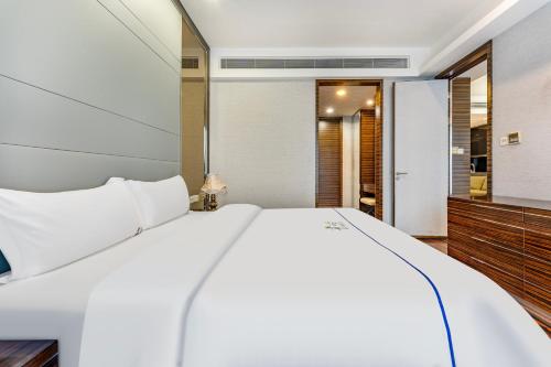 a bedroom with a white bed and a bathroom at eStay Residence·Poly World Trade Center Guangzhou in Guangzhou
