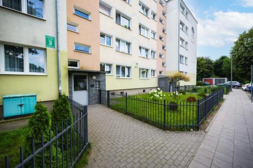 un bâtiment avec une clôture à côté d'un trottoir dans l'établissement Orange by OneApartments, à Gdańsk