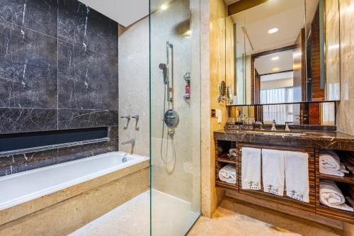 a bathroom with a tub and a glass shower at eStay Residence·Poly World Trade Center Guangzhou in Guangzhou