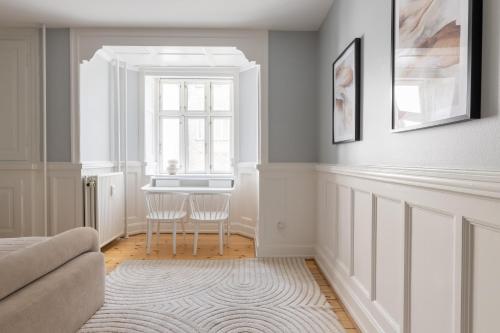 a living room with a table and a window at Unique 3 Bedroom Apartment in Vibrant Frederiksberg in Copenhagen