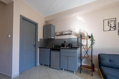 a kitchen with blue cabinets and a blue door at Boutique Studios & Apartments - by Avelink in Spáta