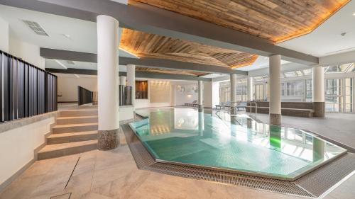 a pool in the middle of a building with columns at Wellnesshotel Eggerwirt in Sankt Michael im Lungau