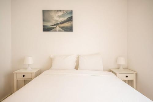 a bedroom with a white bed with two night stands at GuestReady - Sunny Sesimbra Escape in Sesimbra