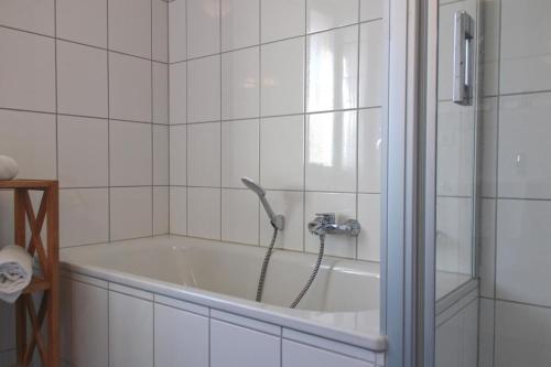 a bath tub with a faucet in a bathroom at Inselblume 55 - Ferienwohnung in der Strandburg mit Hund in Burgtiefe auf Fehmarn 