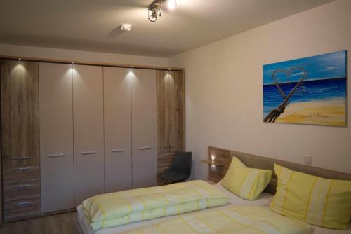 una camera da letto con un letto e un quadro sul muro di Inselblume 44 - Ferienwohnung mit Balkon im Zentrum von Burg a Burg auf Fehmarn