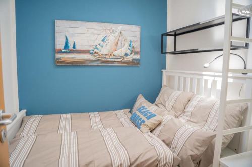 a bedroom with a bed and a painting of boats at Inselblume 78 - Ferienwohnung mit Strandkorb in Burgtiefe in Burgtiefe auf Fehmarn 