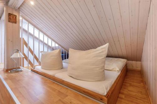 un lit dans une chambre avec deux oreillers dessus dans l'établissement Inselblume 18 - Ferienwohnung mit Meerblick & Galerie in der Strandburg, à Burgtiefe auf Fehmarn 