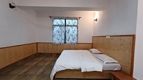 a bedroom with a bed and a window at Twin Garden in Gangtok
