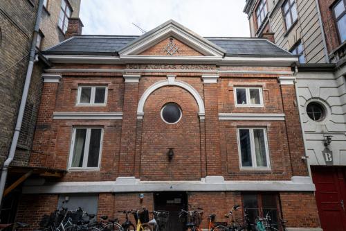 a brick building with bikes parked outside of it at Unique 3 Bedroom Apartment in Vibrant Frederiksberg in Copenhagen
