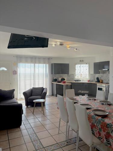une cuisine et un salon avec une table et des chaises dans l'établissement Appartement 7 personnes face mer 7BLION37, au Barcarès