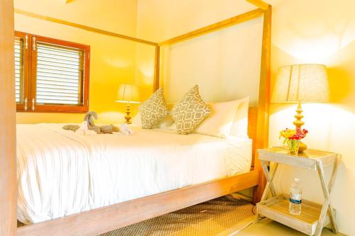 a bedroom with a white bed with a wooden frame at Stunning 4 bed Villa in Bequia St Vincent in Bequia