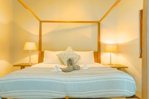 a teddy bear sitting on a bed with two lamps at Stunning 4 bed Villa in Bequia St Vincent in Bequia