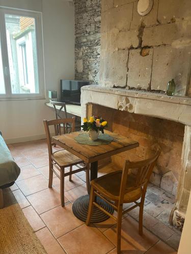 a table and chairs in a living room with a fireplace at Studio CENTRE VILLE ANGERS 1ER ETAGE - 2 PERSONNES in Angers