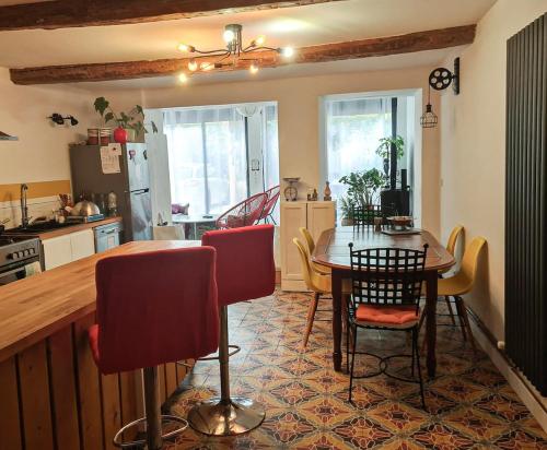 une cuisine avec une table et des chaises dans une cuisine dans l'établissement La Vigneronne between river and sea, à Sérignan