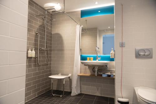 a bathroom with a sink and a shower at Holiday Inn Express Caen Epron by IHG in Caen