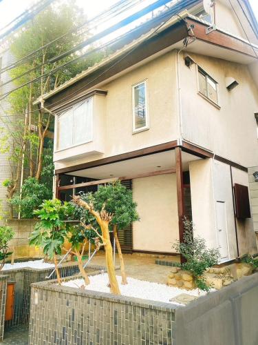 a house with a tree in front of it at Spacious Traditional Japanese House with Modern Amenities near Shibuya for Families and Groups up to 8 Guests in Tokyo