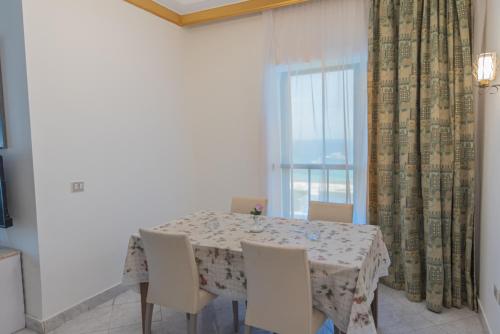 a dining room with a table and chairs and a window at Dexon Roma Hotel in Hurghada