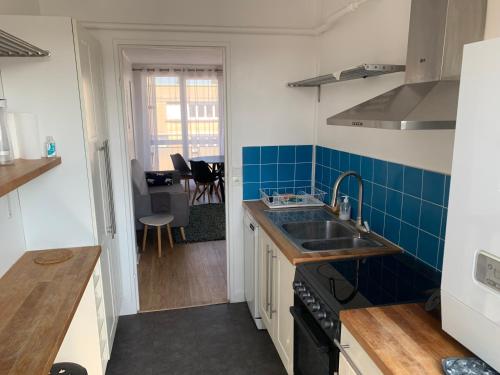une petite cuisine avec un évier et une cuisinière dans l'établissement Les Clés de Saint-Jean - Prox Port et Centre Ville, à Caen