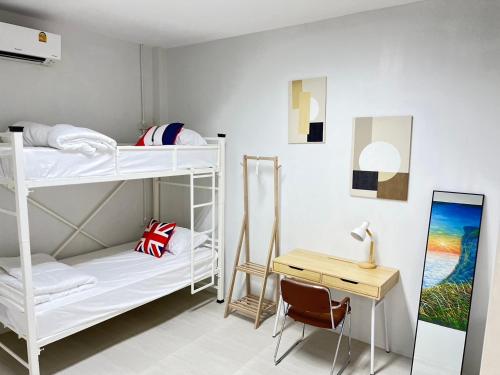 a room with two bunk beds and a desk at Stay at Go Green Chiang Rai in Chiang Rai