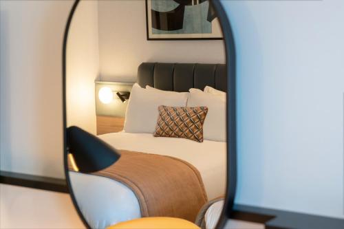 a reflection of a bed in a mirror at Crowne Plaza Birmingham City by IHG in Birmingham