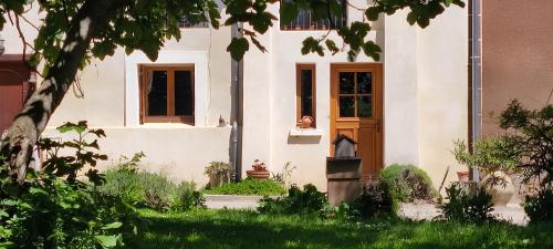 a white house with a dog sitting in the window at Les jardins du Canal in Sainte-Eulalie