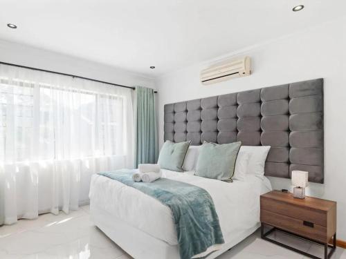 a bedroom with a large bed with a large headboard at At 40 Oceanview in Durban