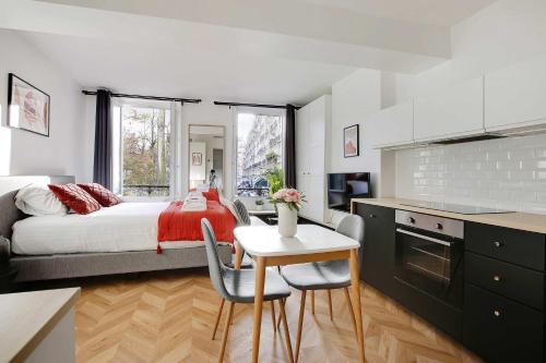 une chambre avec un lit, une table et des chaises dans l'établissement Bastille - Elegant Studio 2 persons, à Paris