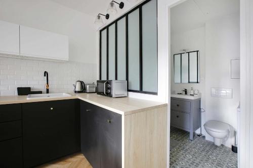 Il comprend une cuisine avec un lavabo et des toilettes. dans l'établissement Bastille - Elegant Studio 2 persons, à Paris
