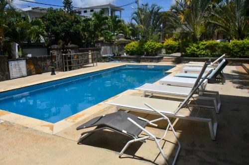 una fila di sedie a sdraio accanto alla piscina di Villas Rocher a Fond du Sac