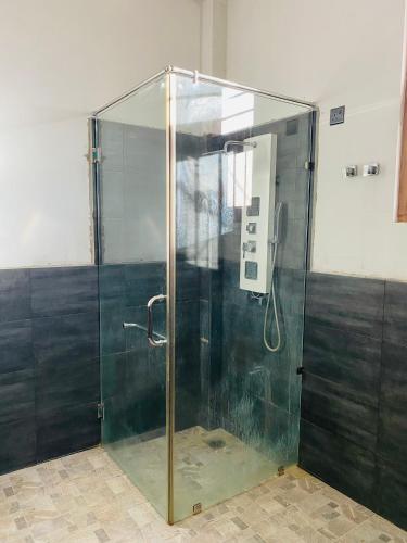 a shower with a glass enclosure in a room at Lago Inn in Tissamaharama