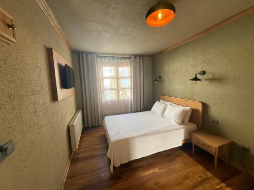 a small bedroom with a bed and a window at Bay Nihat Otel Lale in Ayvalık