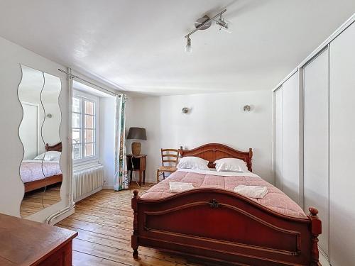 une chambre avec un lit en bois dans une pièce dans l'établissement Hypercentre maison de ville, rue piétonne animée, à Clermont-Ferrand