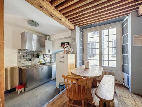 une cuisine avec une table et un réfrigérateur dans l'établissement Hypercentre maison de ville, rue piétonne animée, à Clermont-Ferrand