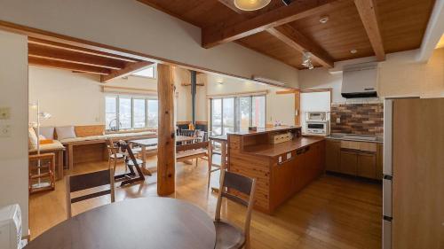 a kitchen and living room with a table and chairs at Cottage Roots コテージルーツ in Hida