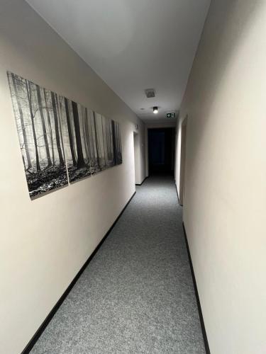an empty hallway with two paintings on the wall at Wielkopolanka Pokoje gościnne i Restauracja in Chodzież
