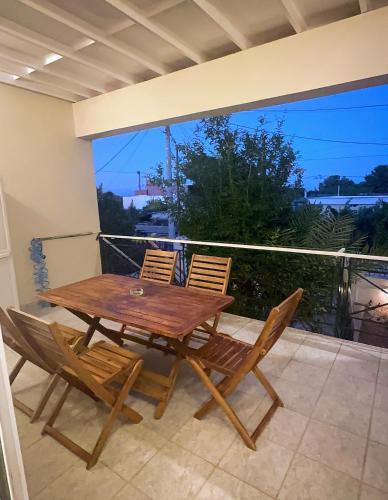 a wooden table and chairs on a balcony at Artemida Beach House in Artemida