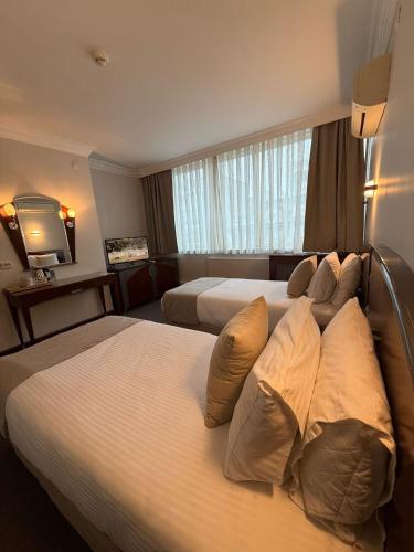 a hotel room with two beds and a television at OTEL KÂYA in Izmir
