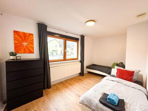 a bedroom with a bed and a window and a couch at Apartment for large groups south of Berlin in Großbeeren