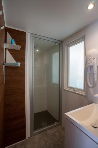 a bathroom with a glass shower and a sink at Happy Camp Mobile Homes in Valamar Camping Lanterna in Poreč
