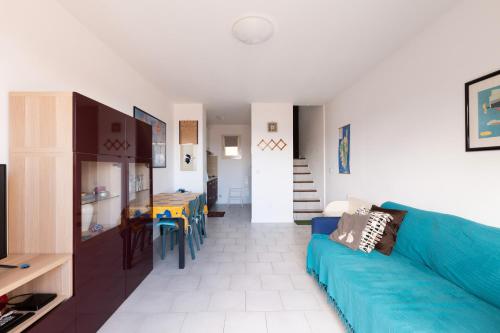un salon avec un canapé bleu et une salle à manger dans l'établissement I Certali, à LʼÎle-Rousse