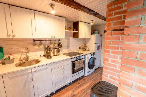 a kitchen with a sink and a brick wall at Saarelux Riverise Villa in Mõraste