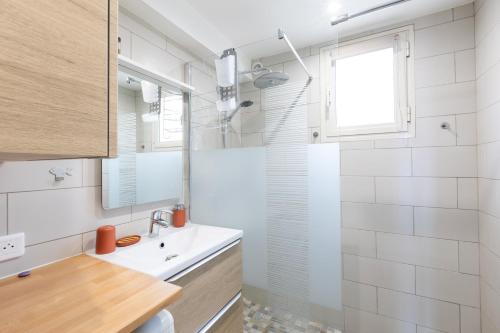 une salle de bain blanche avec un lavabo et une douche dans l'établissement I Certali, à LʼÎle-Rousse