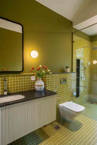 a bathroom with a sink and a toilet and a mirror at LohonoStays Villa Kefi in Assagao
