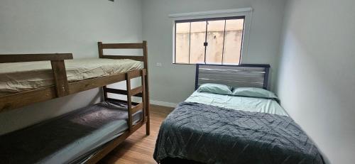a bedroom with two bunk beds and a window at Casa Espetacular, 3 suites, luxo! in Maringá
