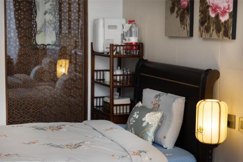 a bedroom with a bed with a lamp next to it at Datong Yunzhong Traditional Courtyard in Datong