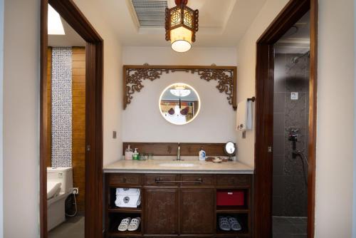 a bathroom with a sink and a mirror at Datong Yunzhong Traditional Courtyard in Datong